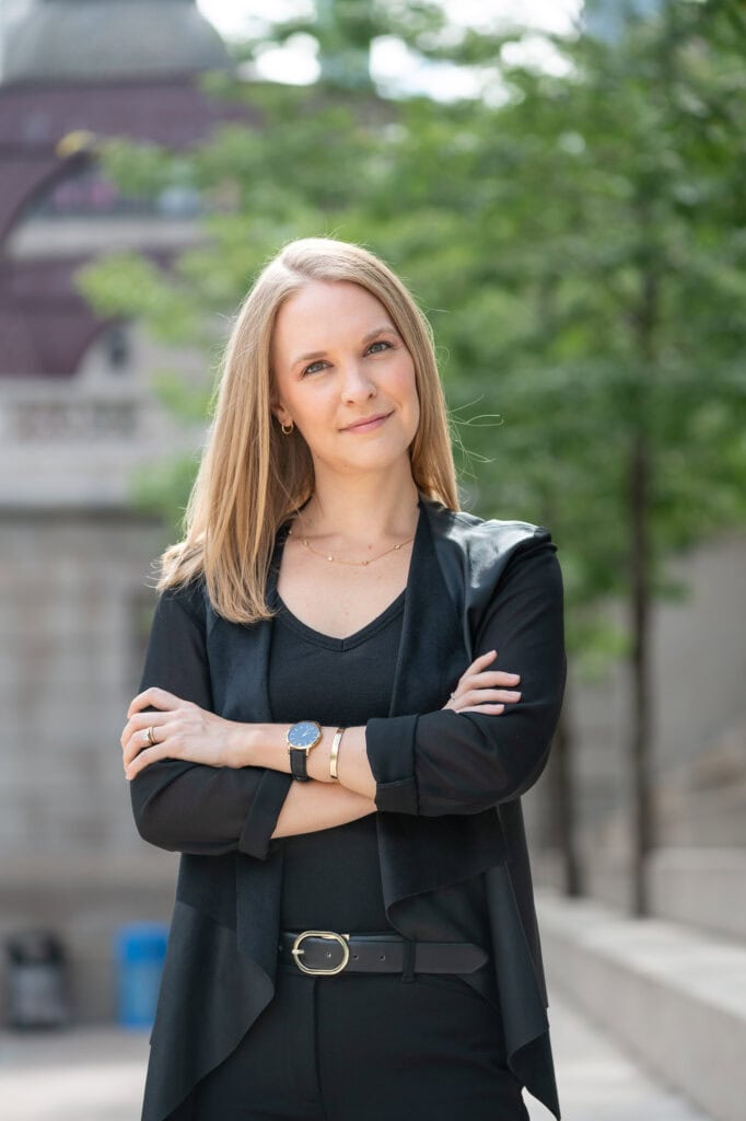 proofing gallery edit of woman wearing black stands with arms crossed by the chicago riverwalk during a branding photo session for her magazine editorial