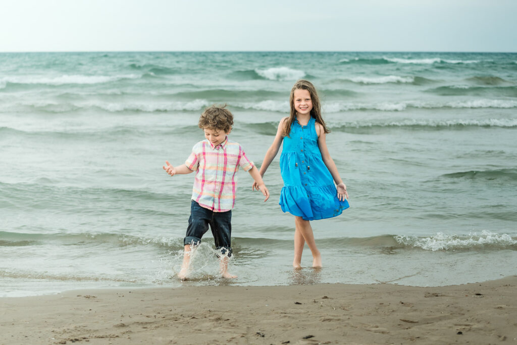 Kids kick in the water on a beach in Chicago