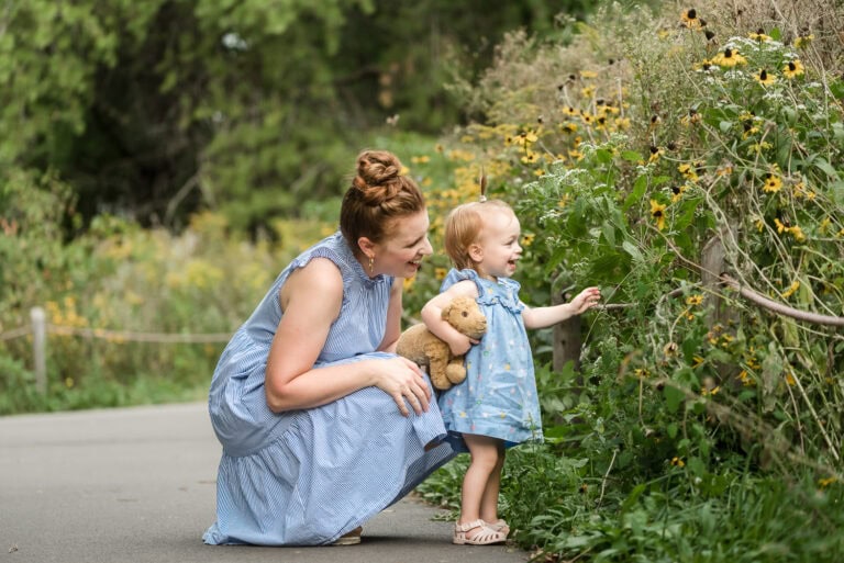 Mom and Daughter look at Black Eyed Susans growing off of trail at Montrose Bird Sanctuary