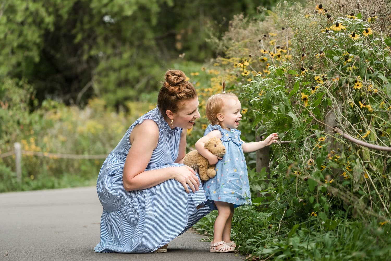 Mom and Daughter look at Black Eyed Susans growing off of trail at Montrose Bird Sanctuary