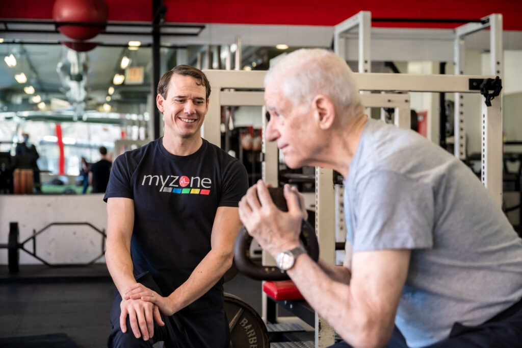 David Burnett working with a client on squats in a gym in Chicago