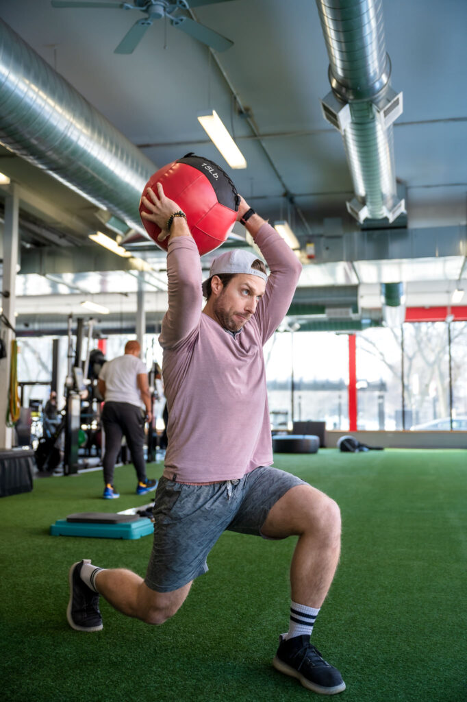 man uses weighted exercise ball during a personal training session in a Chicago gym