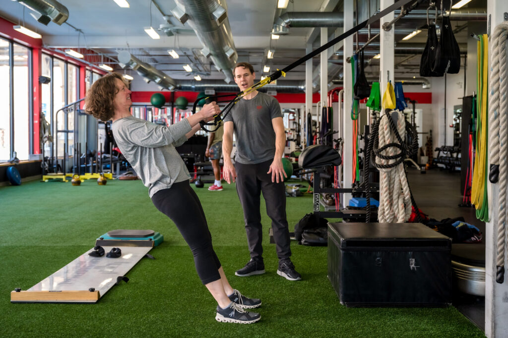 David Burnett works with a woman using resistance bands during a personal training session