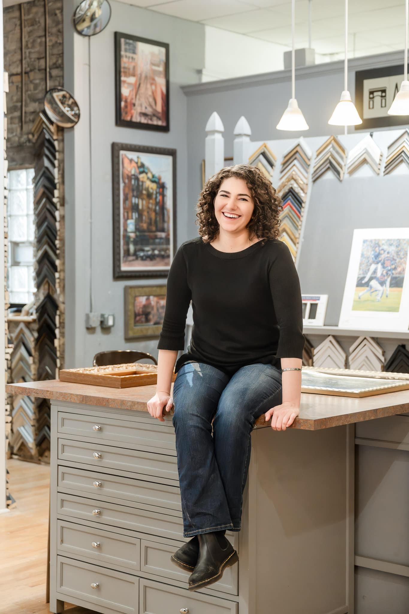 Hope Dye of the Artful Framer sits on the counter of her shop