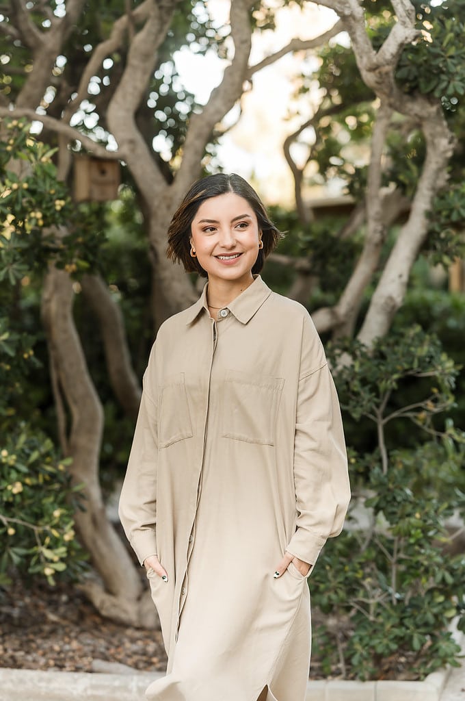 woman wearing khaki walks through tropical garden