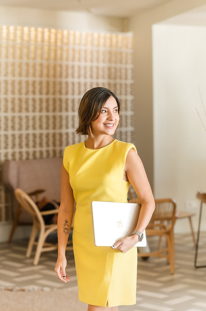 Woman holding laptop looks over her shoulder in a hotel lobby