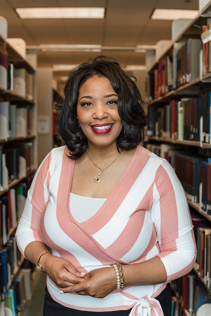 Woman working in education stands in library at DePaul University in Chicago