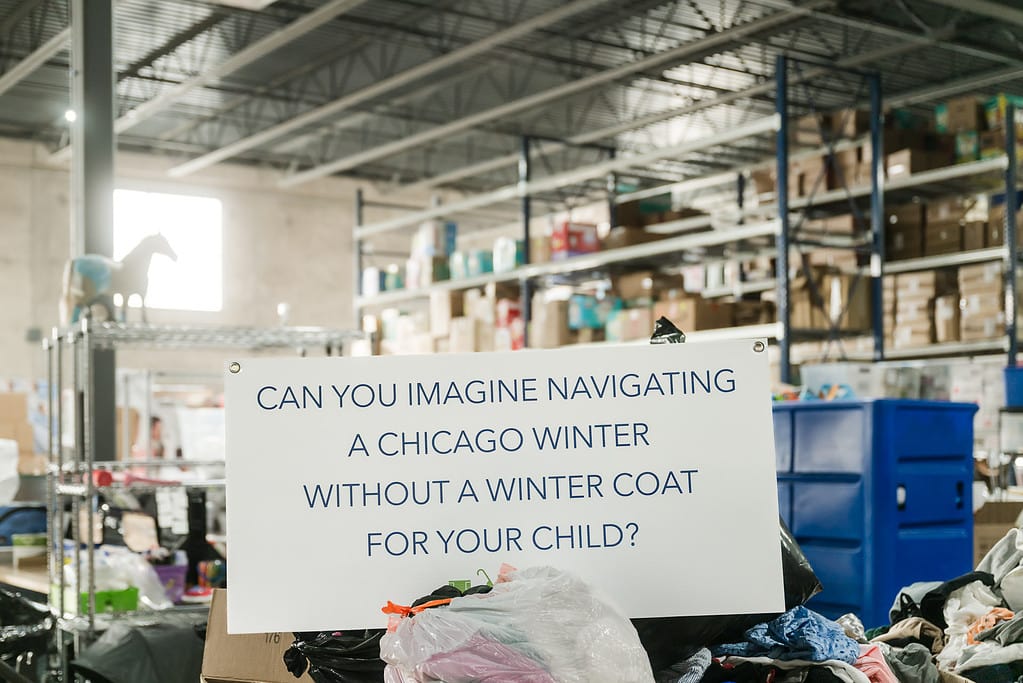 Sign placed in warehouse that asks, can you imagine navigating a Chicago winter without a coat for your child?