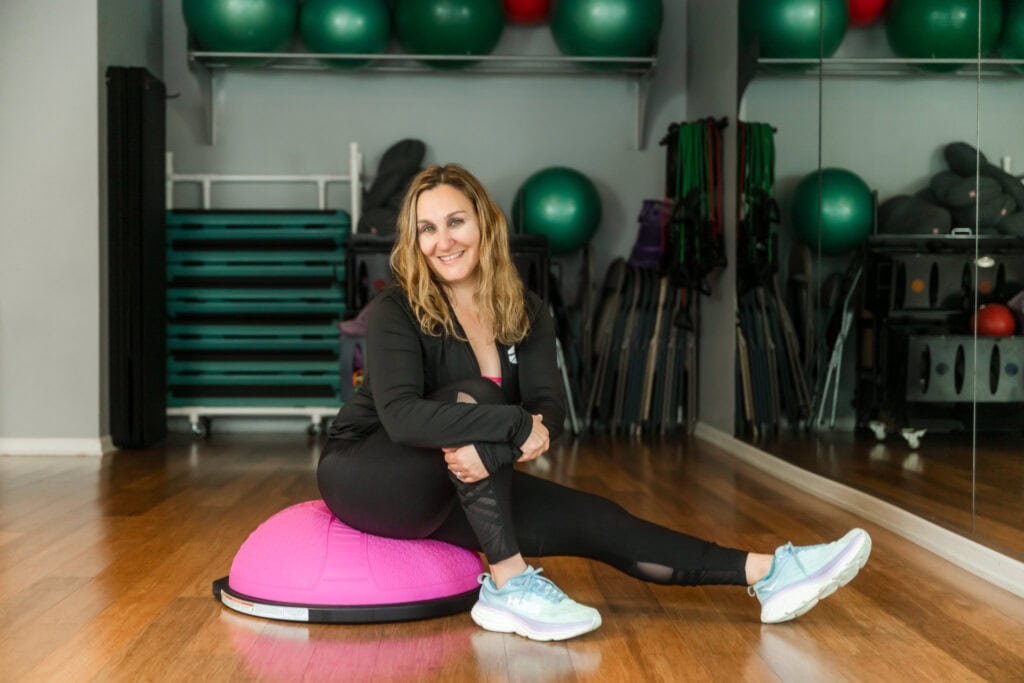 After Edits - Prenatal Fit Owner sits on bright pink Bosu ball in her studio