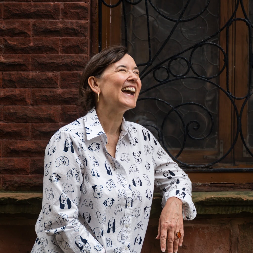 Vertical crop of Woman stands in alley by a dark window textured background and laughs