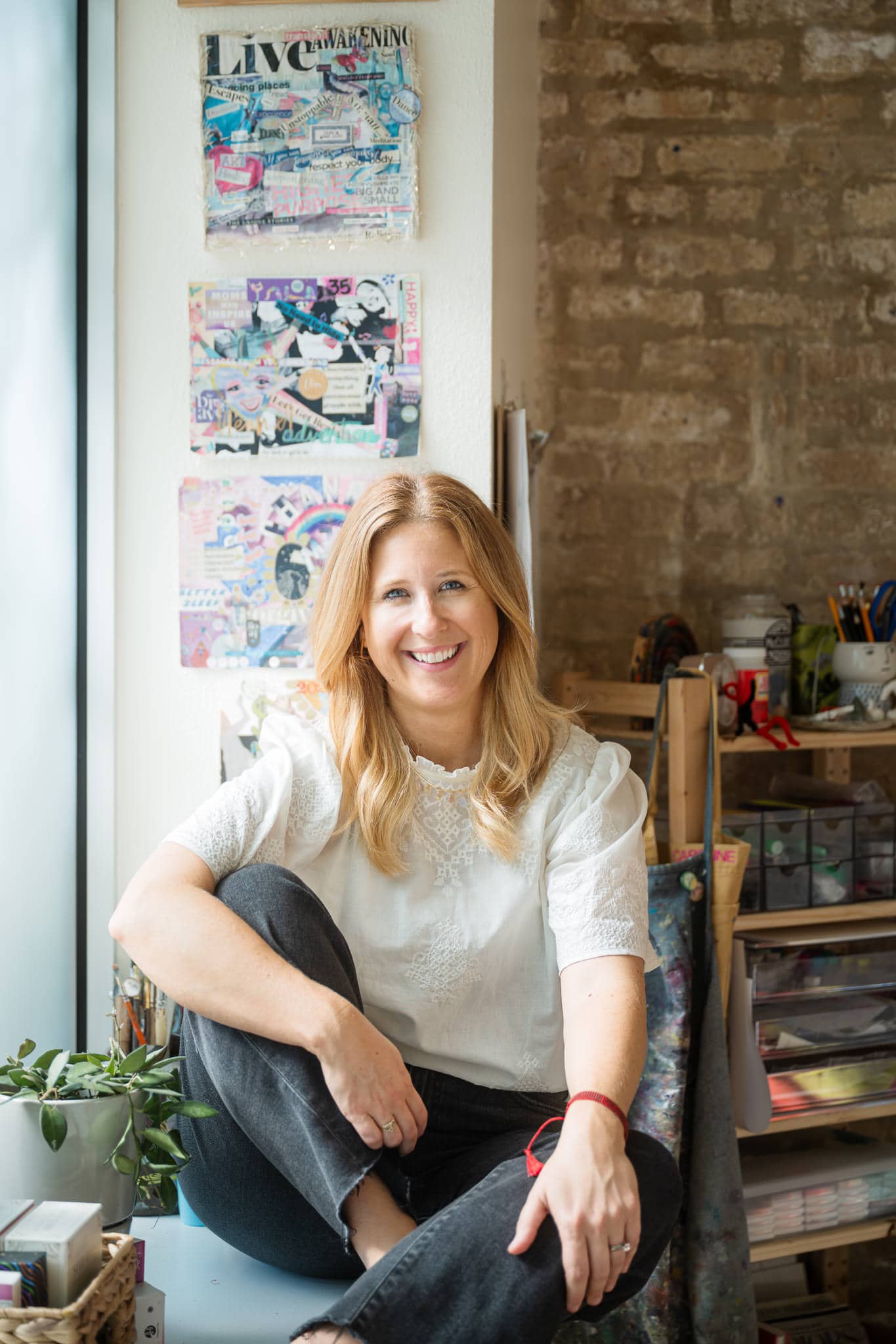 Woman sits on windowsill of art studio at her art therapy practice: Dandelion Therapeutic Art Center in Chicago