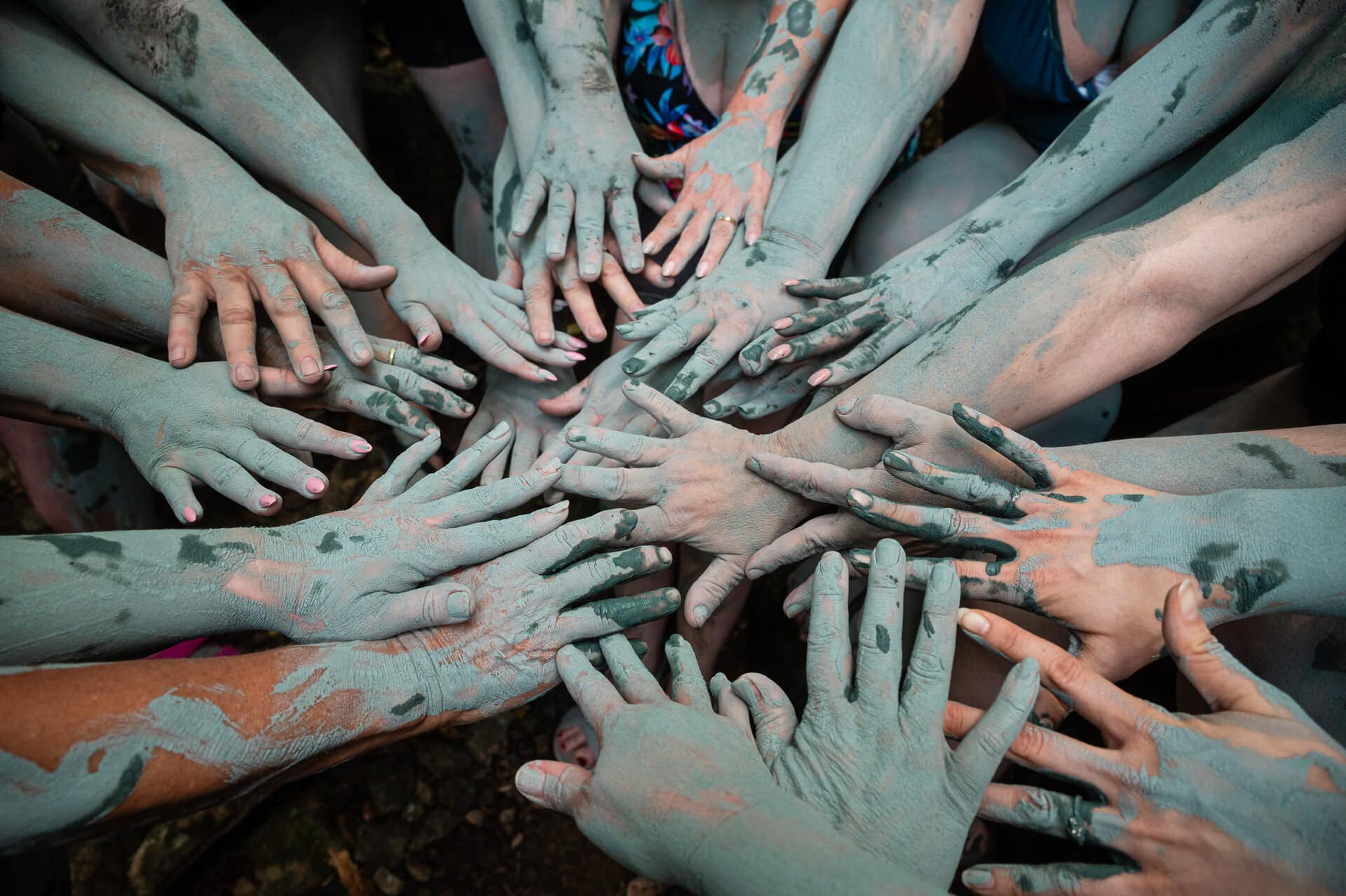 Hands connecting together at the end of a blue clay ceremony in Costa Rica during a Reclaim Your Peace retreat by Chicago's Heather Vickery